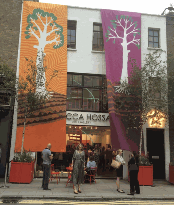Rebecca Hossack outside the gallery with Jimmy Pike's banners