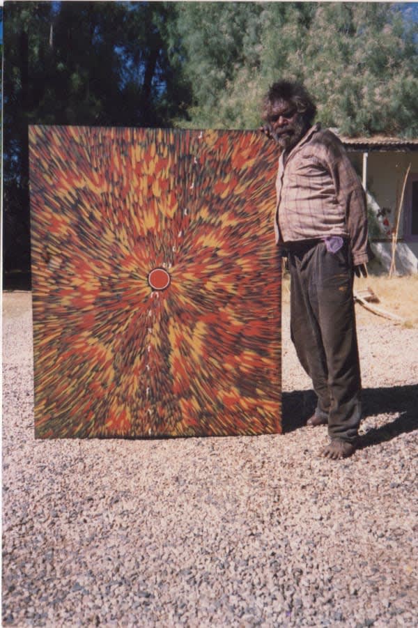 Johnny Warrangkula Tjupurrula with his picture 'fire dreaming' in 1989