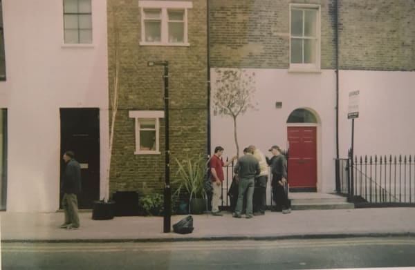Group of people planting a tree in front of a building in Fitzrovia, London