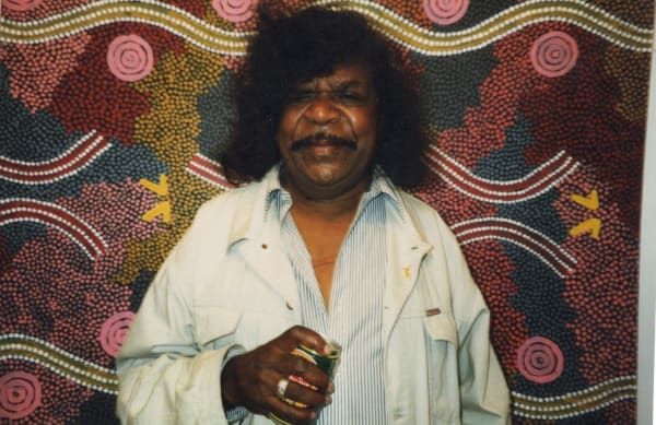 Clifford Possum in front of his painting at the Rebecca Hossack Art Gallery