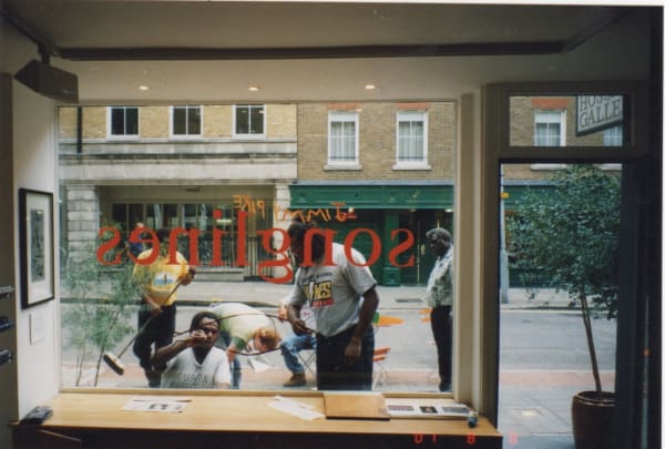 David Bosun, Billy Missi and Dennis Nona painting on the window at the Rebecca Hossack Art Gallery for Dugong My Son Exhibition