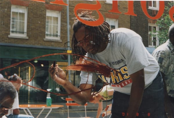 David Bosun painting on the window of the Rebecca Hossack Art Gallery for Songlines Exhibition