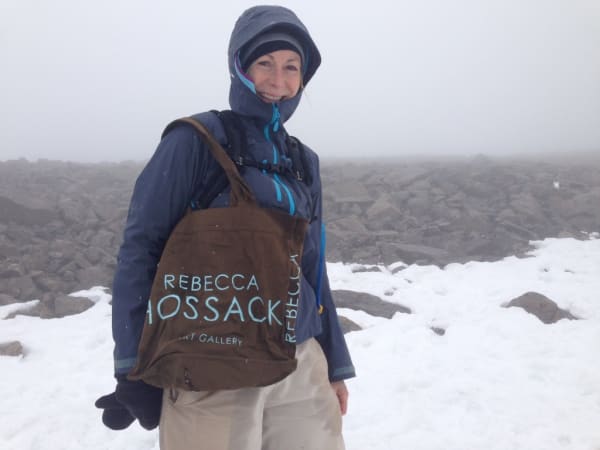 Rebecca Hossack with Rebecca Hossack Art Gallery bag on Ben Nevis