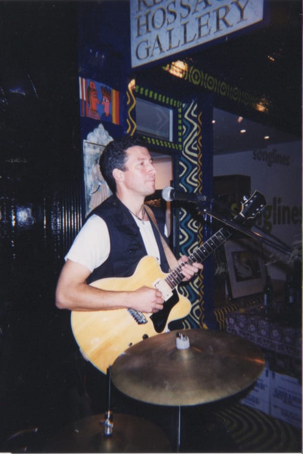BBC reporter playing the guitar outside Rebecca Hossack Art Gallery