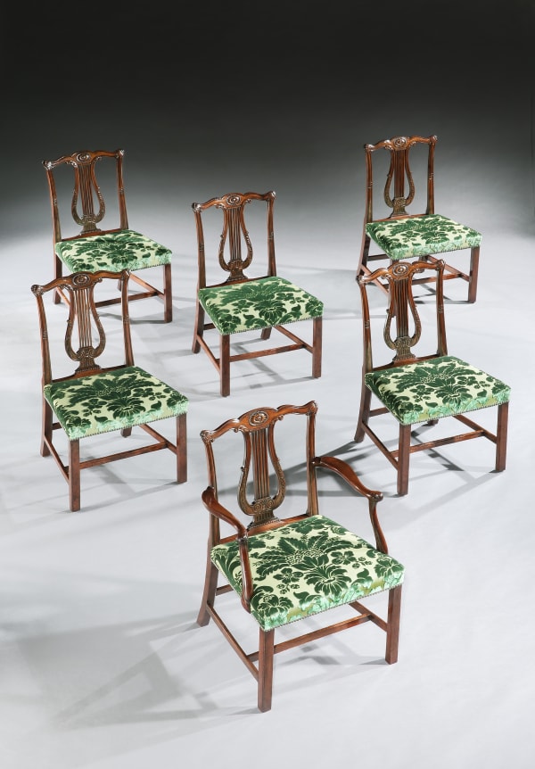 A set of twelve George III mahogany dining chairs to a design by Robert Adam and attributed to Thomas Chippendale.