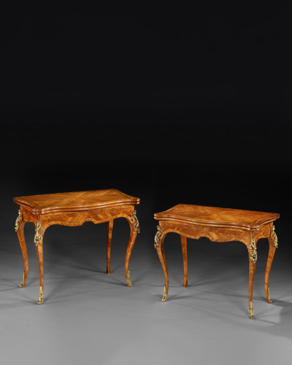A pair of George III ormolu mounted kingwood and tulipwood concertina action card tables attributed to Christopher Fuhrlohg.