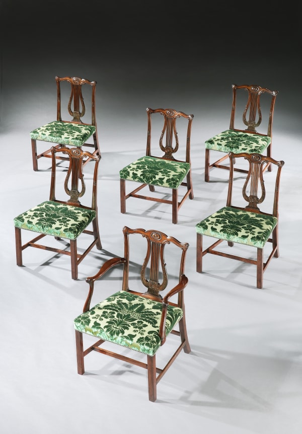 A set of twelve George III mahogany dining chairs to a design by Robert Adam and attributed to Thomas Chippendale.