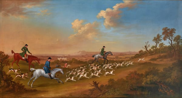 Huntsmen following hounds towards a covert, a country house in the distance