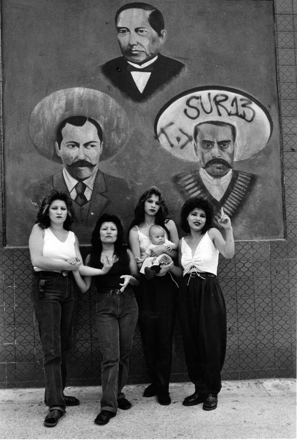 Graciela Iturbide, Cholas I (con Zapata y Villa) White Fence, East L.A., 1986, Signed by the artist in ink on recto, Silver Gelatin Print, 20 x 16" 50.8 x 40.6 cm