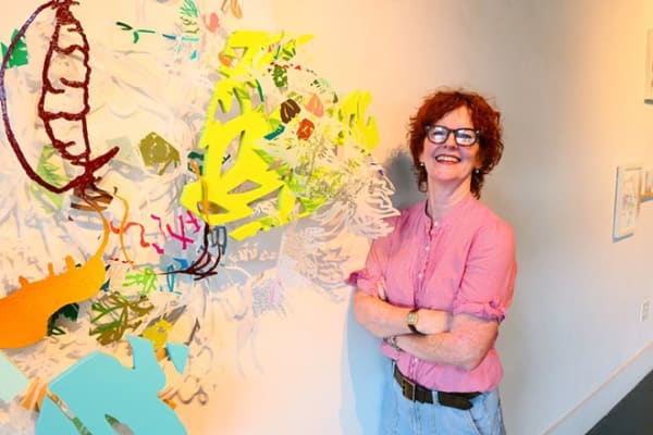 Leigh Anne Lester stands beside one of her creations at Ruiz-Healy Art, Image by Bryan Rindfuss
