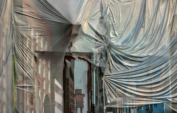 The wall of a building is draped in transparent plastic, allowing us to see the painted surface beneath. The surface seems to be a mural of a city scene, comprising brick and concrete high-rise windowed city buildings, and a bridge over a blue river. Spac