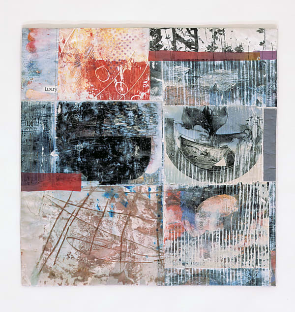 This quilt is divided into six collaged rectangles, each patterned with multiple textures. Greys, light blues and rust are the quilt’s predominant colors, with pops of red and brighter blue in places. The rectangles on the right hand side of