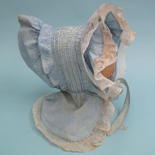Pale blue 19th century sun bonnet with a lace trim. There is some age-related fading but it would be ideal for TV, film or theatre production.