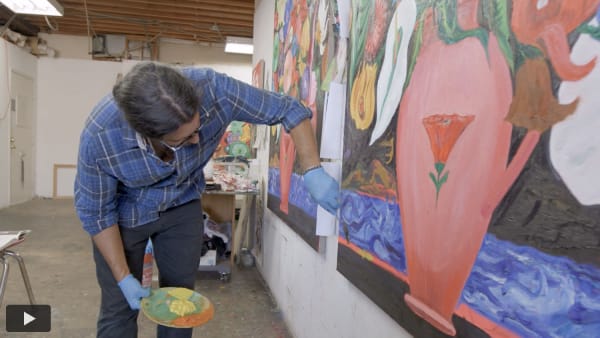 Daniel Gibson painting in his studio with a play button in the lower left corner