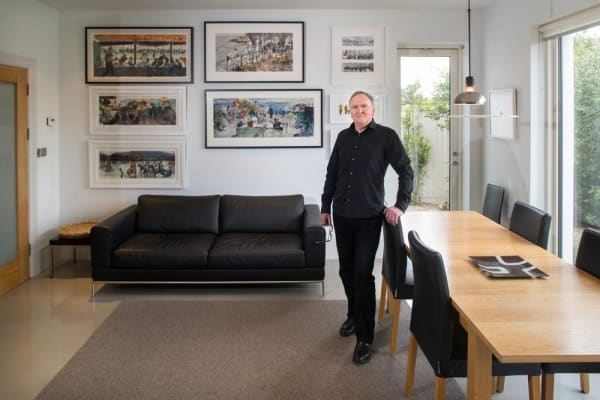 Artist John Short in the dining area of his newly remodelled house. Dating from the 1960s, the house now has higher ceilings, large expanses of glass and some concrete floors. The paintings will all feature in John's forthcoming exhibition