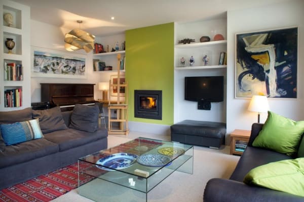 The living room is furnished with a mix of expensive and reasonably priced pieces, combining to create an edgy living space. John and Helen like colour, so they often change the lime panel to a different shade