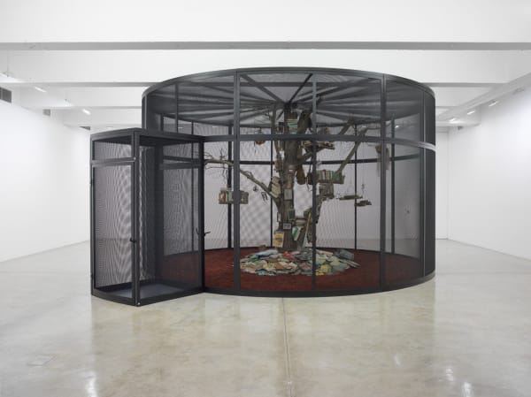 Cage with tree inside and birds and books