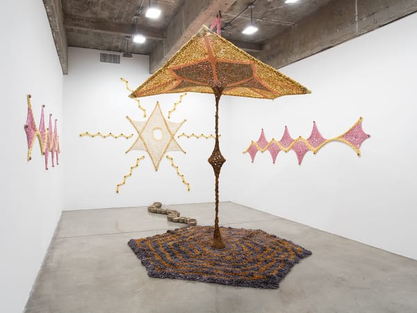 Ernesto Neto installation with crochet in middle of room and crochet on the wall
