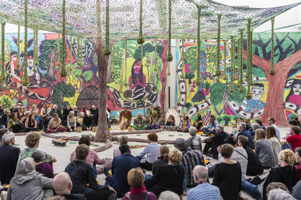 People gathered around crochet tree installation