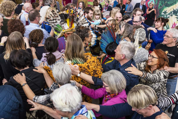 People gathered around crochet tree installation