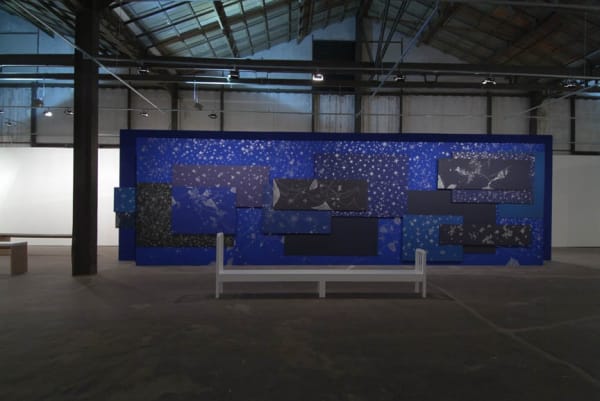 image of wall covered in blue paper drawings
