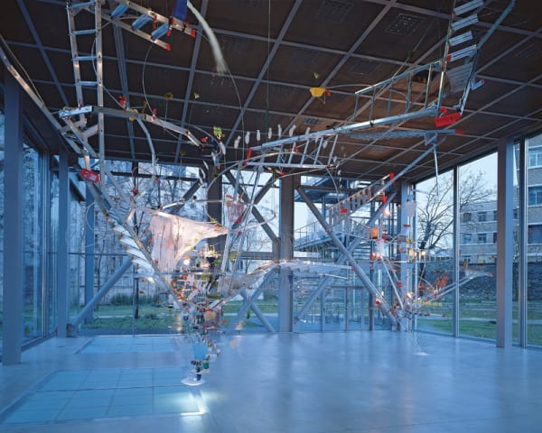 Image of Sarah Sze installation of ladders and other objects circling from ceiling to floor
