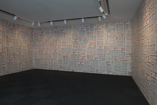 Image of entrance to Phil Collins work at MCA Chicago, walls covered in posters