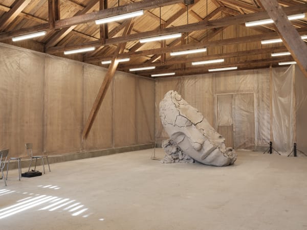 image of Mark Manders installation inside of barn, dry clay head sculpture