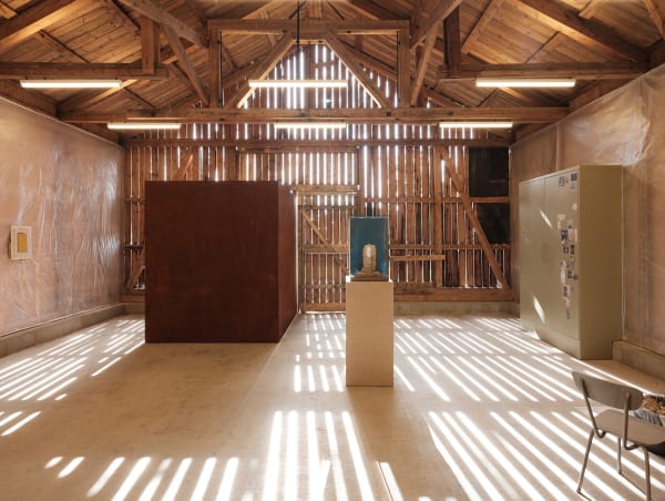 image of Mark Manders installation inside of barn, dry clay head sculpture