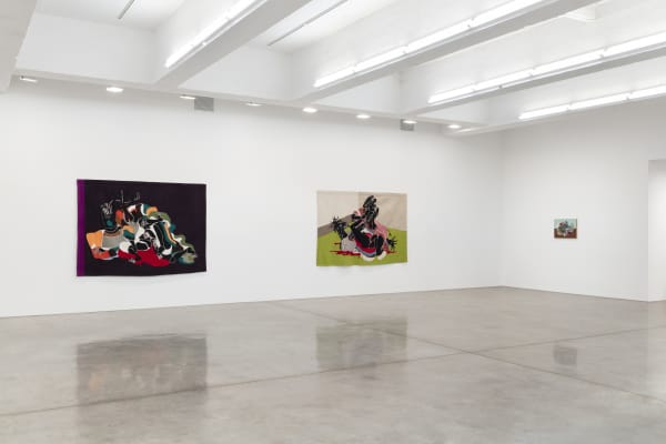 installation view of tapestries and paintings