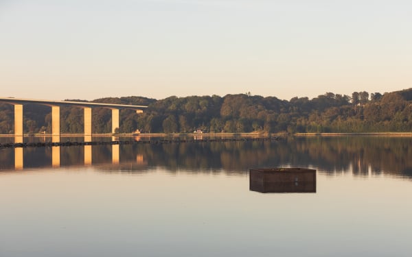 image of a crate floating in the river with fake fruit inside