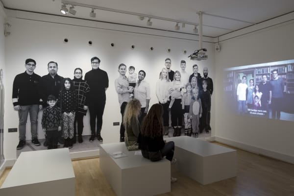 Image of Wearing video installation, still image with wallpaper of people
