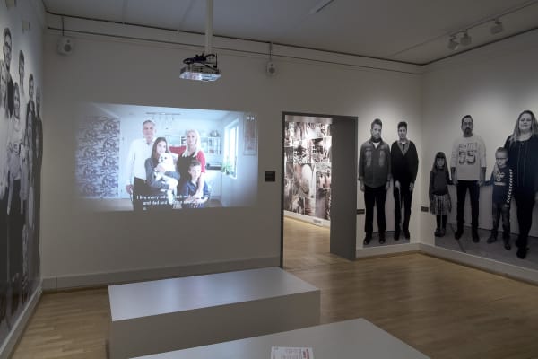 Image of Wearing video installation, still image with wallpaper of people