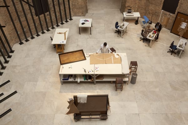 image of tailors sewing / working in a tailor shop set up inside museum, aerial view