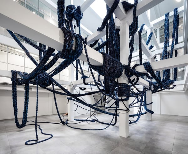 image of braided blue rope hanging from beams and architecture