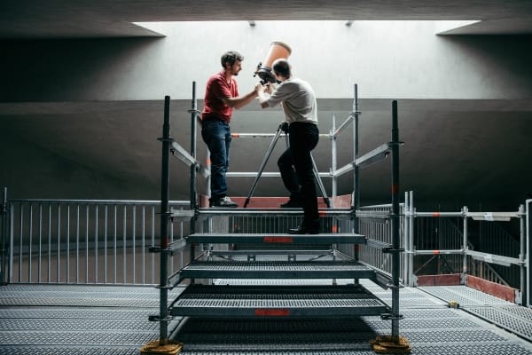 image of two people with a large telescope