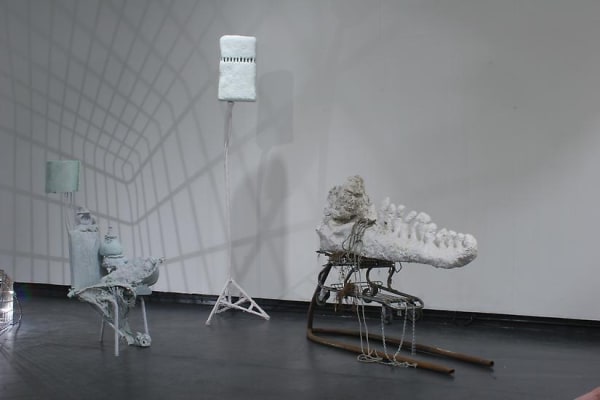 image of installation image of multiple Charles Long white sculptures, dim lighting and shadows