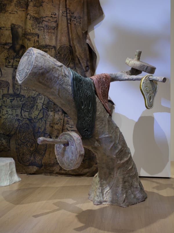 image Charles Long sculpture of rubber tree with masks sliding off