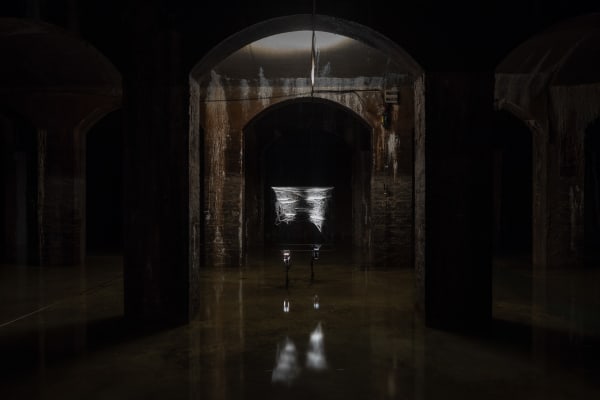 image of Saraceno sculptures hanging in dark room over water