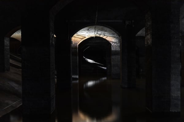 image of Saraceno sculptures hanging in dark room over water