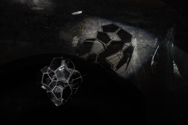 image of Saraceno sculptures hanging in dark room over water