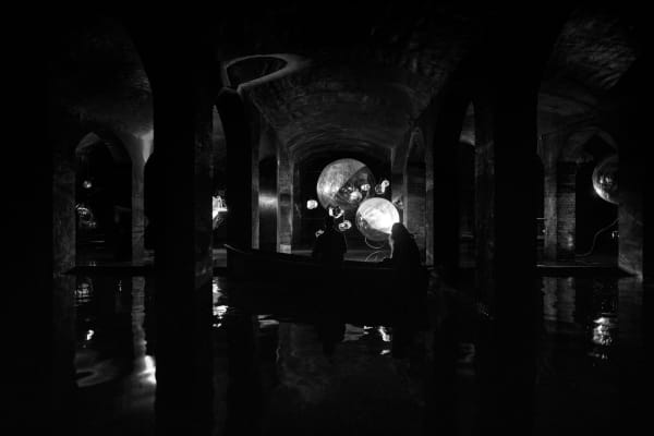 image of Saraceno sculptures hanging in dark room over water
