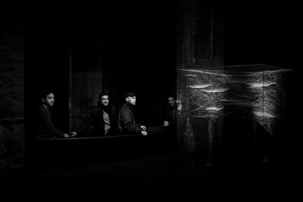 image of Saraceno sculptures hanging in dark room over water