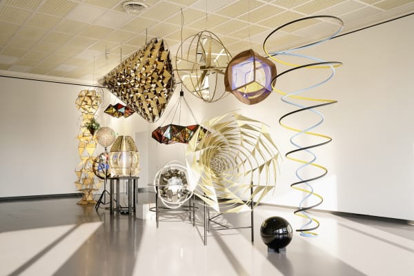 installation of multiple geometric sculptures hanging together