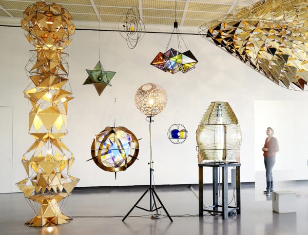 installation of multiple geometric sculptures hanging together