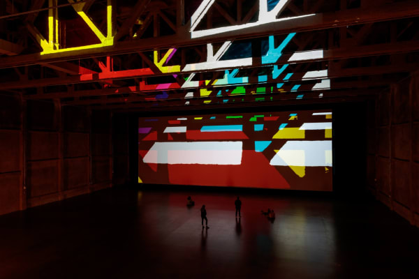 image of installation view large space with color filters and lights projecting onto the wall