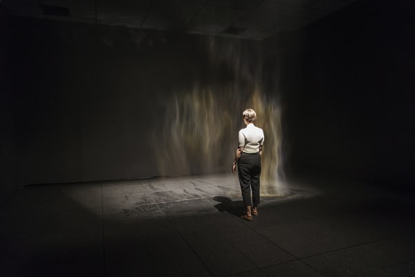 image of mist creating a rainbow in a dark room
