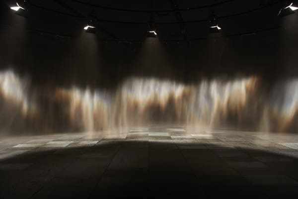image of mist creating a rainbow in a dark room