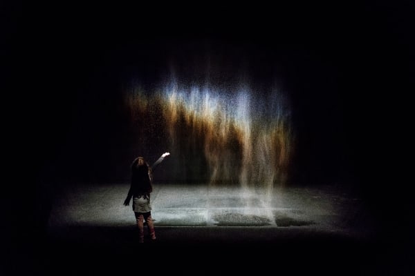 image of mist creating a rainbow in a dark room