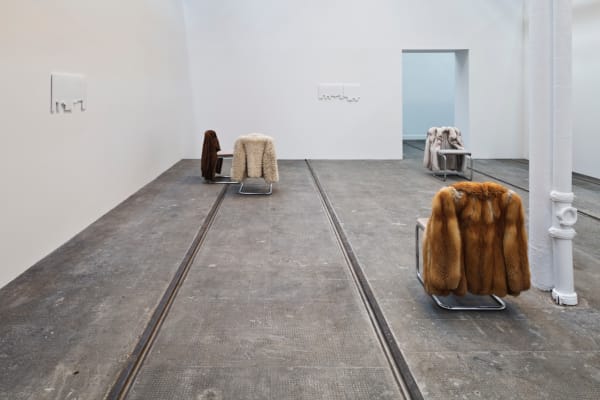 image of chairs with fur coats hanging off of them